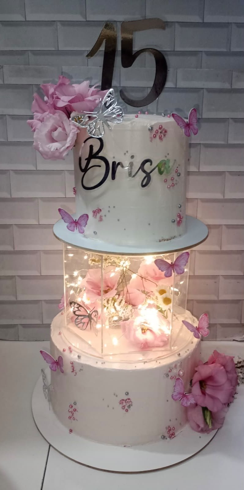 Torta alta de celebración con base decorativa iluminada