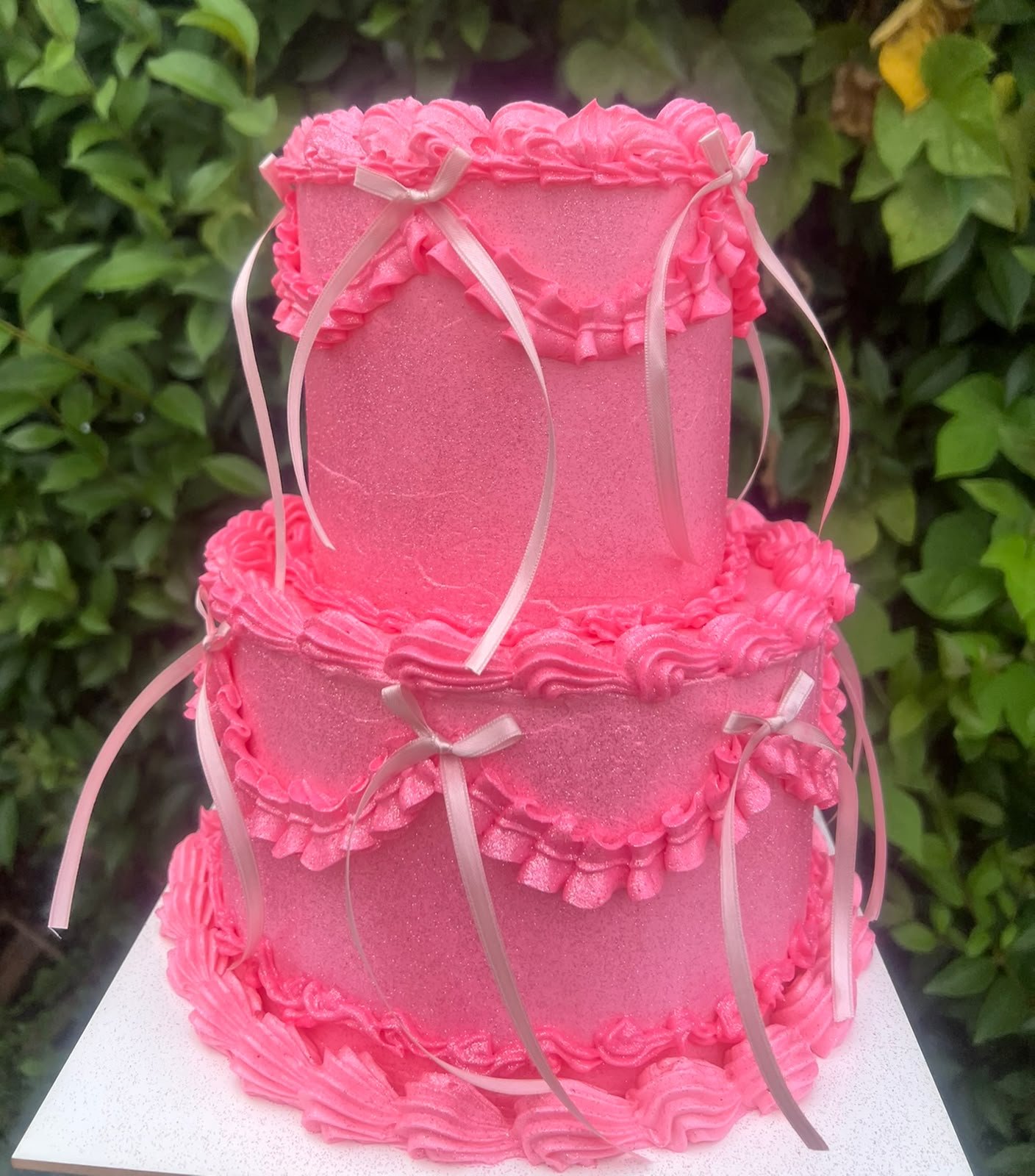 Torta vintage rosa de dos pisos con volados de crema