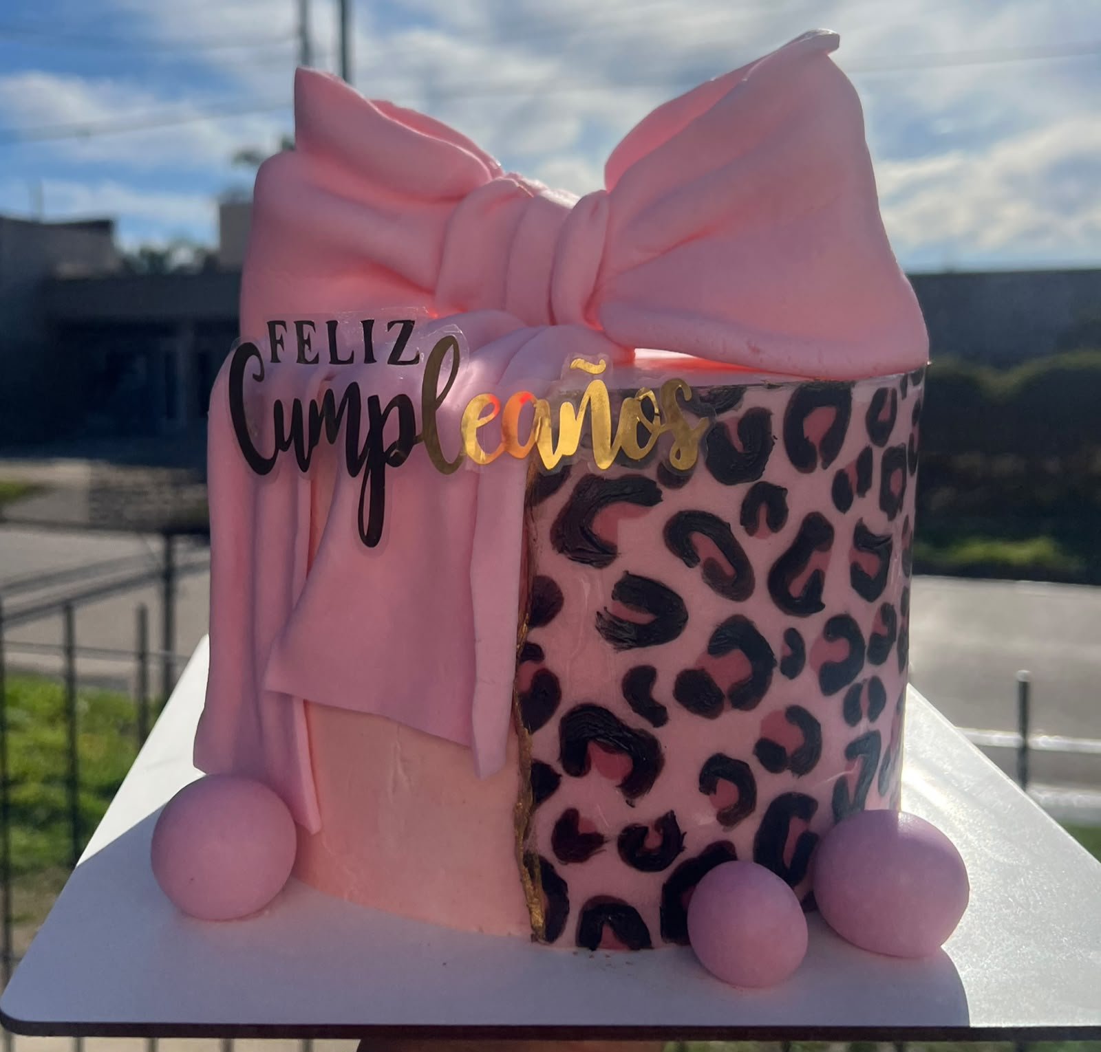 Torta rosa decorada con crema y cintas